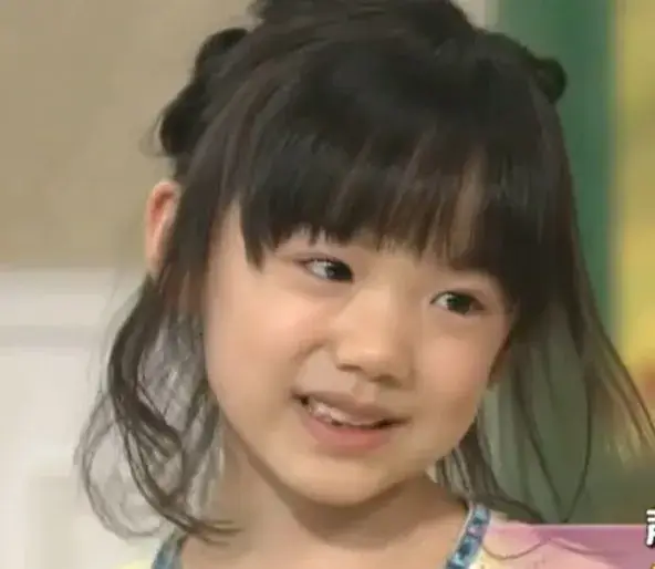 幼い芦田愛菜が優しくほほ笑むシーンで、母親との思い出を感じさせる表情が印象的な写真