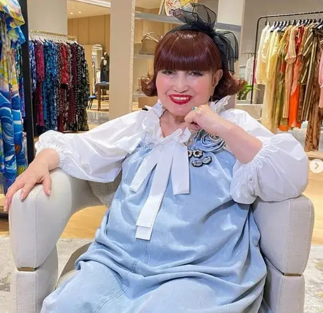 黒柳徹子が年収や資産について語るわけではないが、華やかな服装で椅子に座って微笑む姿の画像