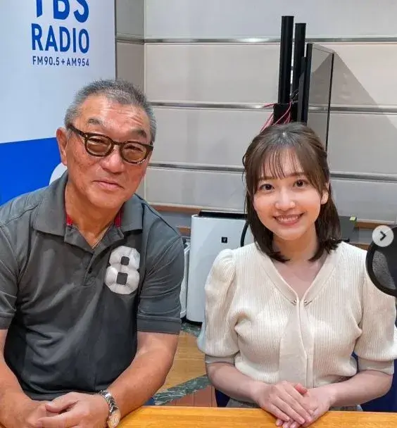 会議室で南後杏子が同僚と並んで座っている姿で、身長の違いがわかるツーショット写真